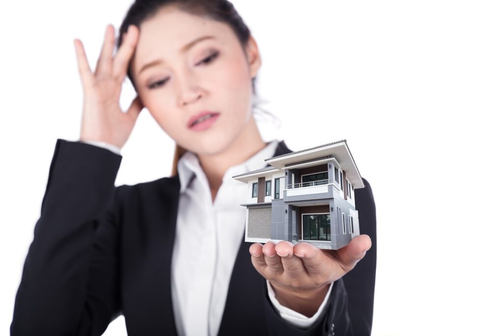 Worried,Business,Woman,Open,Hand,Holding,House,Isolated,On,White