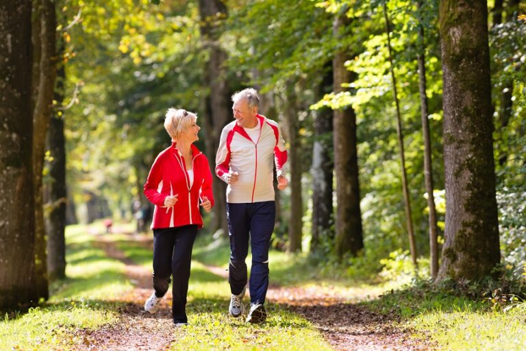 Senior,Couple,Doing,Sport,Outdoors,,Jogging,On,A,Forest,Road