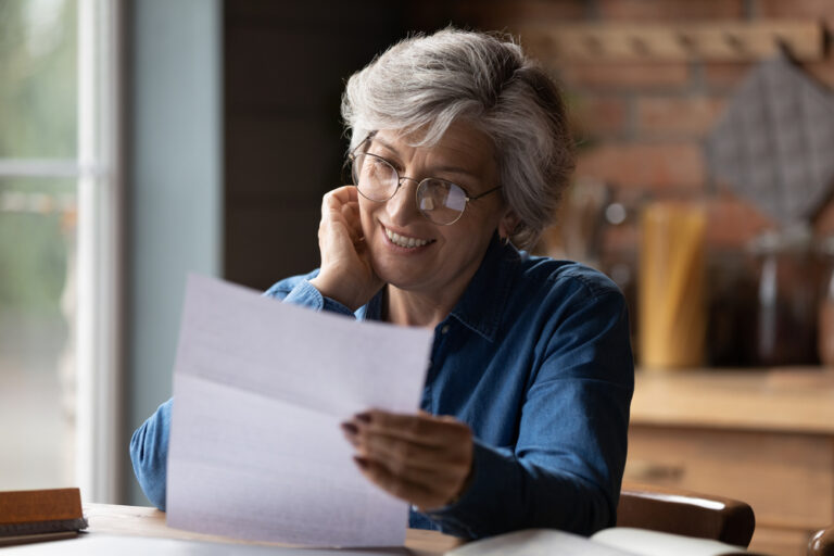 Happy,Mature,60s,Woman,In,Glasses,Sit,At,Table,Manage