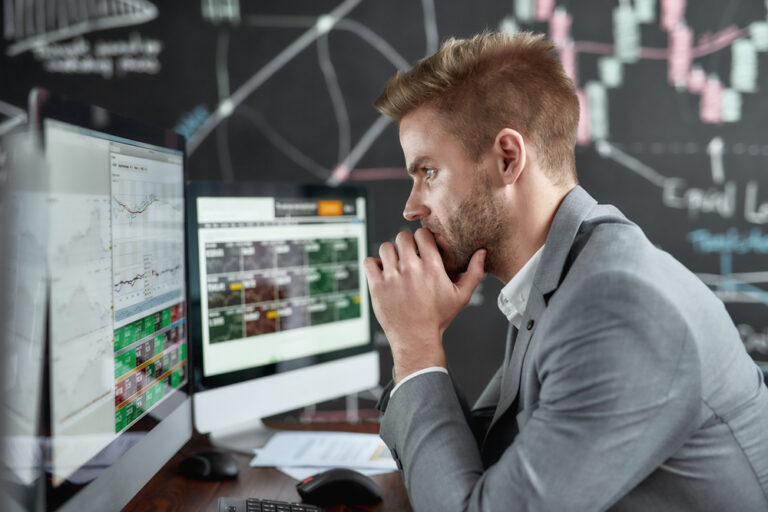 Portrait,Of,Successful,Trader,Looking,Focused,While,Sitting,In,Front