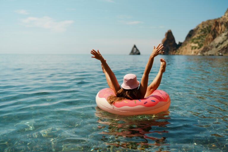 Summer,Vacation,Woman,In,Hat,Floats,On,An,Inflatable,Donut