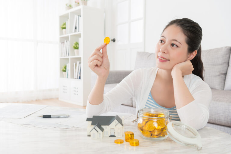 Pretty,Elegant,Housewife,Looking,At,Gold,Coin,In,Living,Room