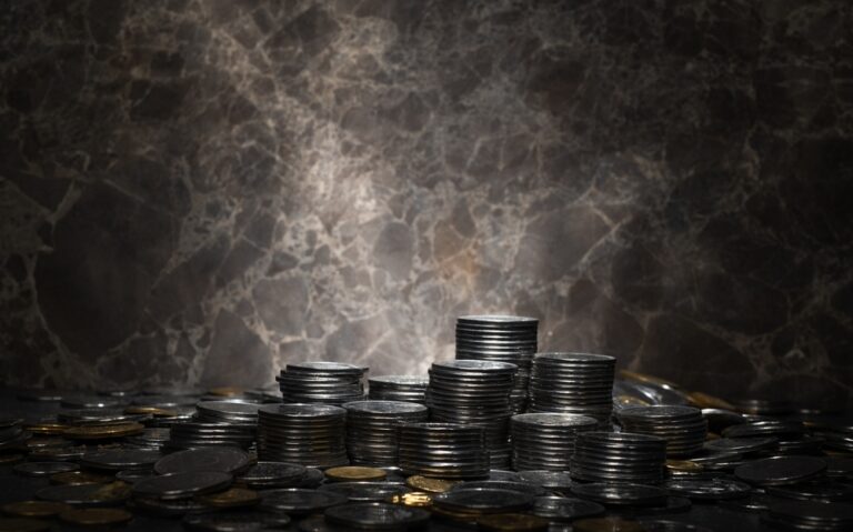 Coins,On,A,Dark,Background.,Coins,Scattered,And,Stacked,For