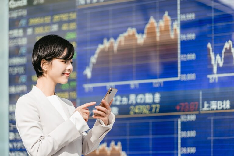 Woman,Watching,A,Smartphone,In,Front,Of,The,Stock,Board