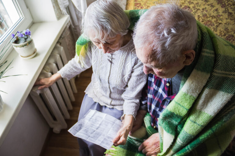 The,Senior,Woman,Holding,Gas,Bill,In,Front,Of,Heating