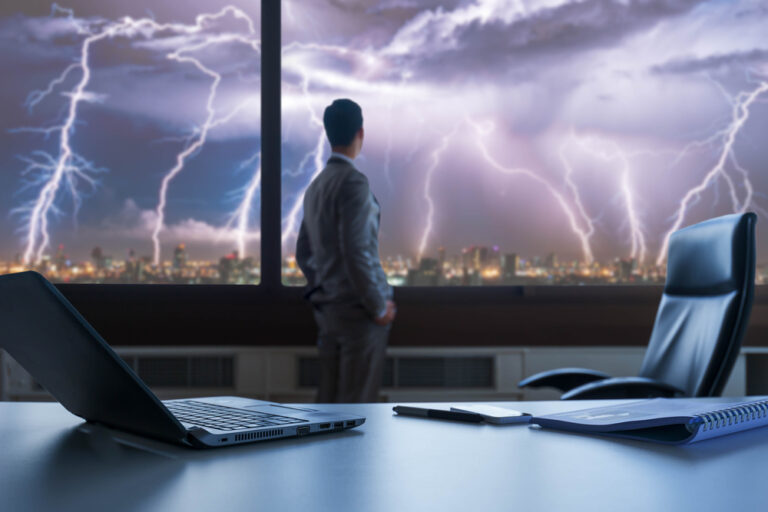 Businessman,Stand,On,Roof,Top,Of,Skyscraper,,Facing,Lightning,Strom,