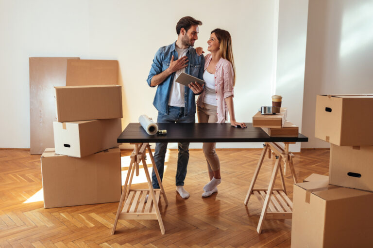 Happy,Young,Couple,Using,A,Tablet,In,Their,New,Home