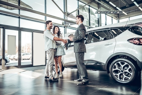 Young couple shaking hands with sales agent after a successful c